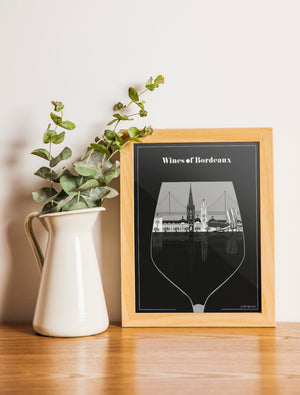 Carte postale illustrée intitulée “Bordeaux, Le Verre de Vin" par Julie Roubergue, représentant de façon graphique les monuments emblématiques de Bordeaux dans un verre de vin en noir et blanc.