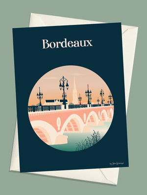 Carte postale illustrée intitulée “Bordeaux, Le Pont de Pierre” par Julie Roubergue, représentant le fameux pont sur la Gironde et la vue de Bordeaux côté rive droite avec un fond bleu profond.